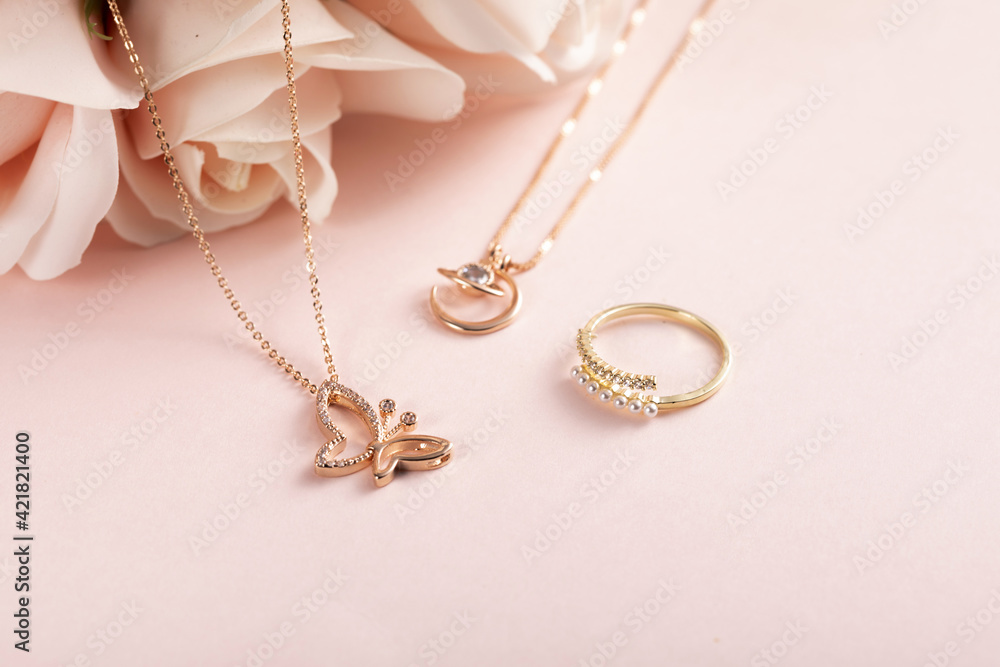 placeholder image of some necklaces on a table with a flower